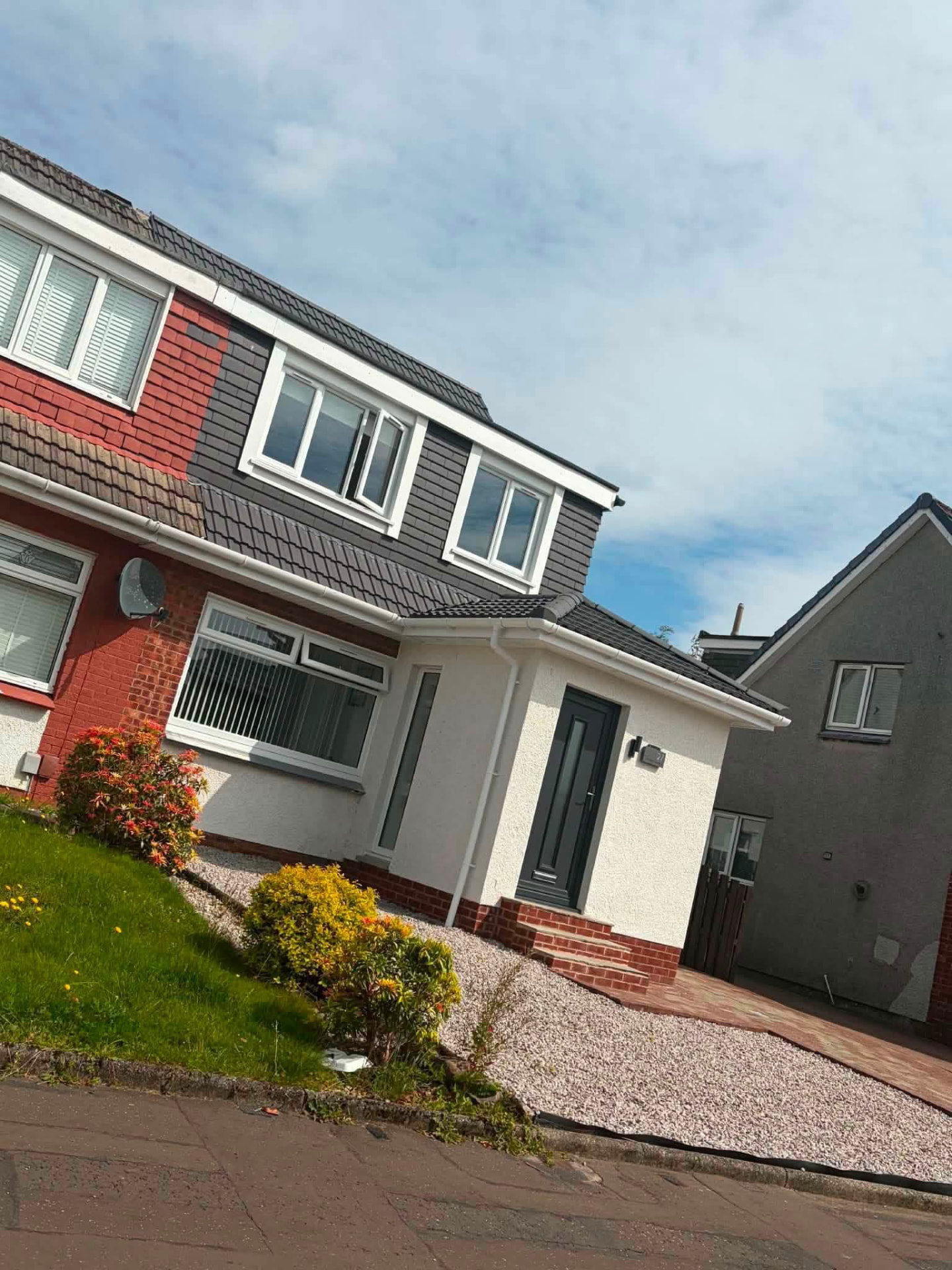 Semi-detached home with new dark roof tiles, clad dormer and porch roof
