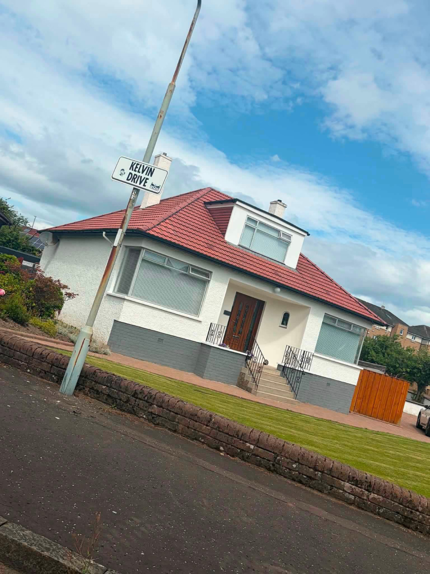 White bungalow with a red tiled roof and dormer window