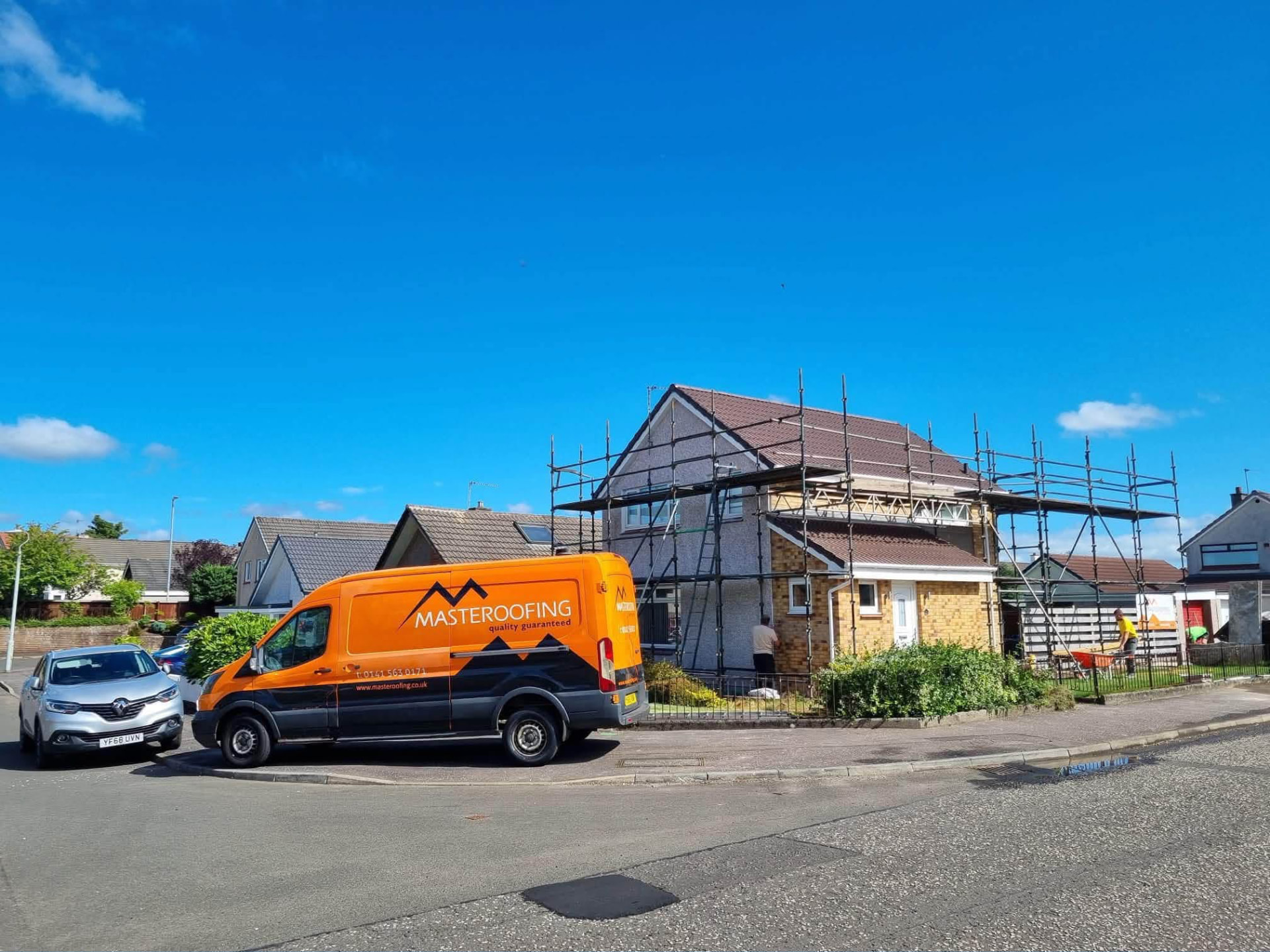 Masteroofing van parked beside a house under scaffolding during roofing work